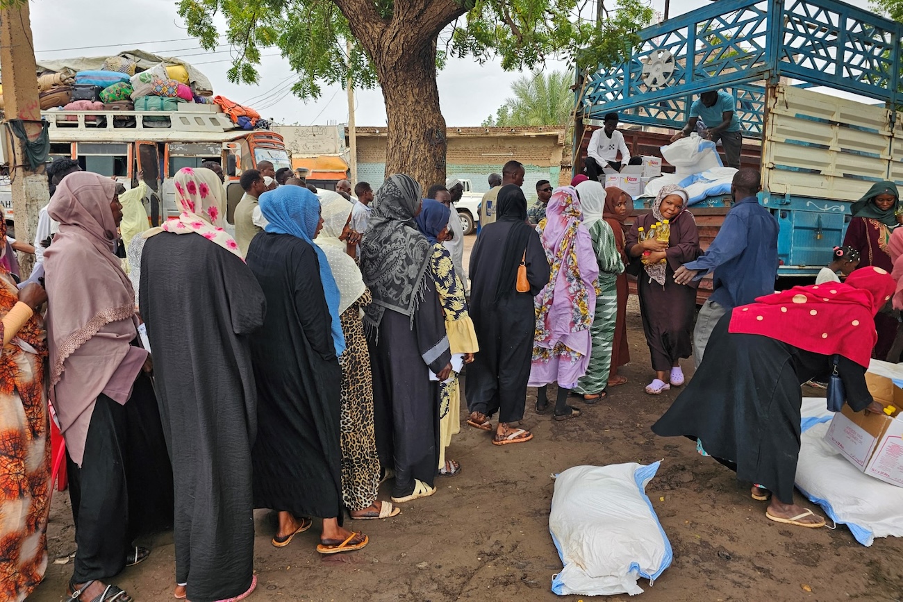 Displaced Sudanese queue to receive humanitarian aid upon their arrival in the capital Khartoum on July 28, 2025. (File/AFP)