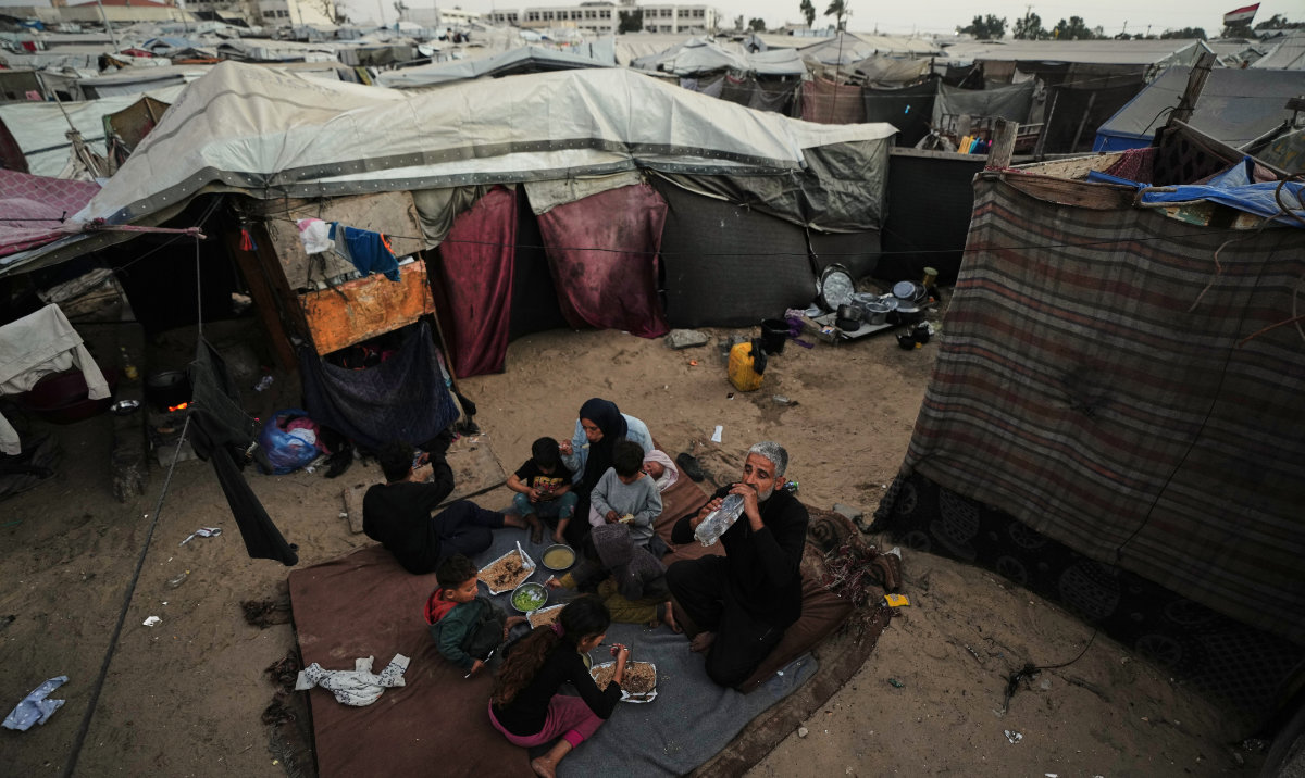 Displaced members of the Al-Zamil family break their fast on the first day of Ramadan inside their tent in Khan Younis, Gaza Strip, Wednesday, Feb. 18, 2026. (AP)