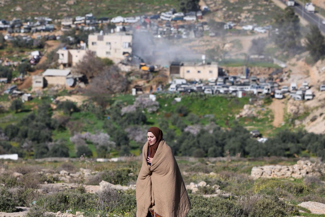 A Palestinian woman reacts as Israeli bulldozers demolish an apartment building belonging to the Salhab family near the Israeli settlement of Hagai, south of the occupied West Bank city of Hebron, on February 18, 2026. (AFP)