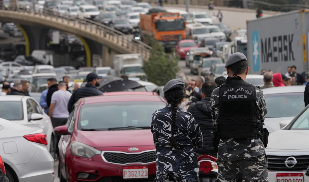 Lebanese police stand in front of taxi drivers who block a main highway during a protest against the increased taxes and gasoline prices in Beirut on Tuesday. (AP)