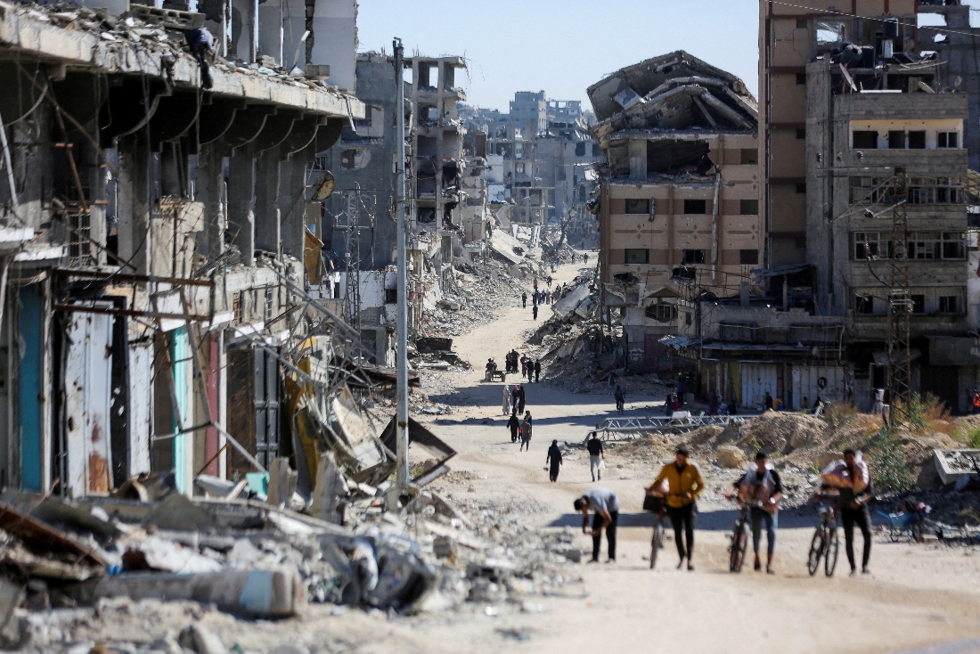 Palestinians make their way in a devasted neighborhood, amid the ongoing Israel-Hamas conflict, in Gaza City. (Reuters)