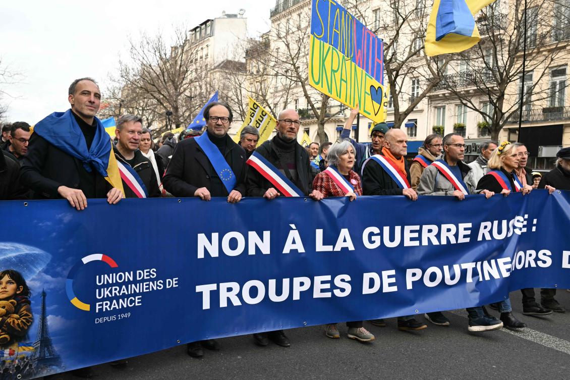 Parti Socialiste (PS) MEP Raphael Glucksmann stands behind a banner reading “No to the Russian war: Putin’s troops out of Ukraine” during a march for Ukraine ahead of the fourth anniversary of Russia’s invasion, in Paris on Feb. 21, 2026. (AFP)