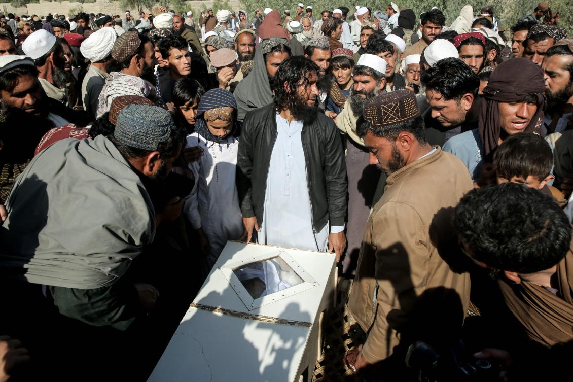 Afghan relatives and mourners surround the body of a victim, killed in an overnight Pakistani air strike, during a mass burial ceremony at the Girdi Kas village in Bihsud district, Nangarhar province on February 22, 2026. (AFP)