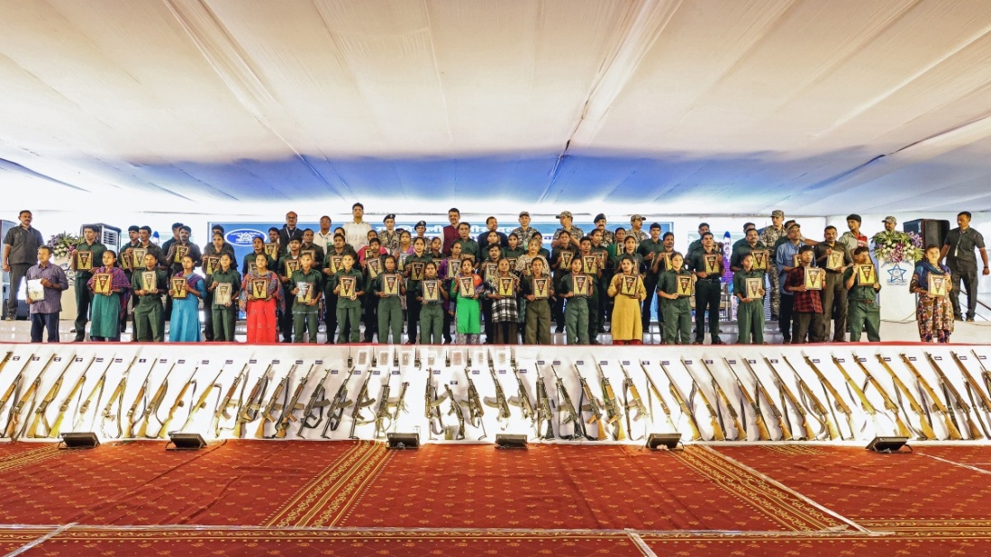 This handout photograph taken on October, 2025, and released by India's Maharashtra state Chief Minister's office shows the state Chief Minister Devendra Fadnavis posing with Maoist rebels and fighters upon their surrender, as they hold copies of the Indian constitution during an event at Gadchiroli in Maharashtra. (AFP)