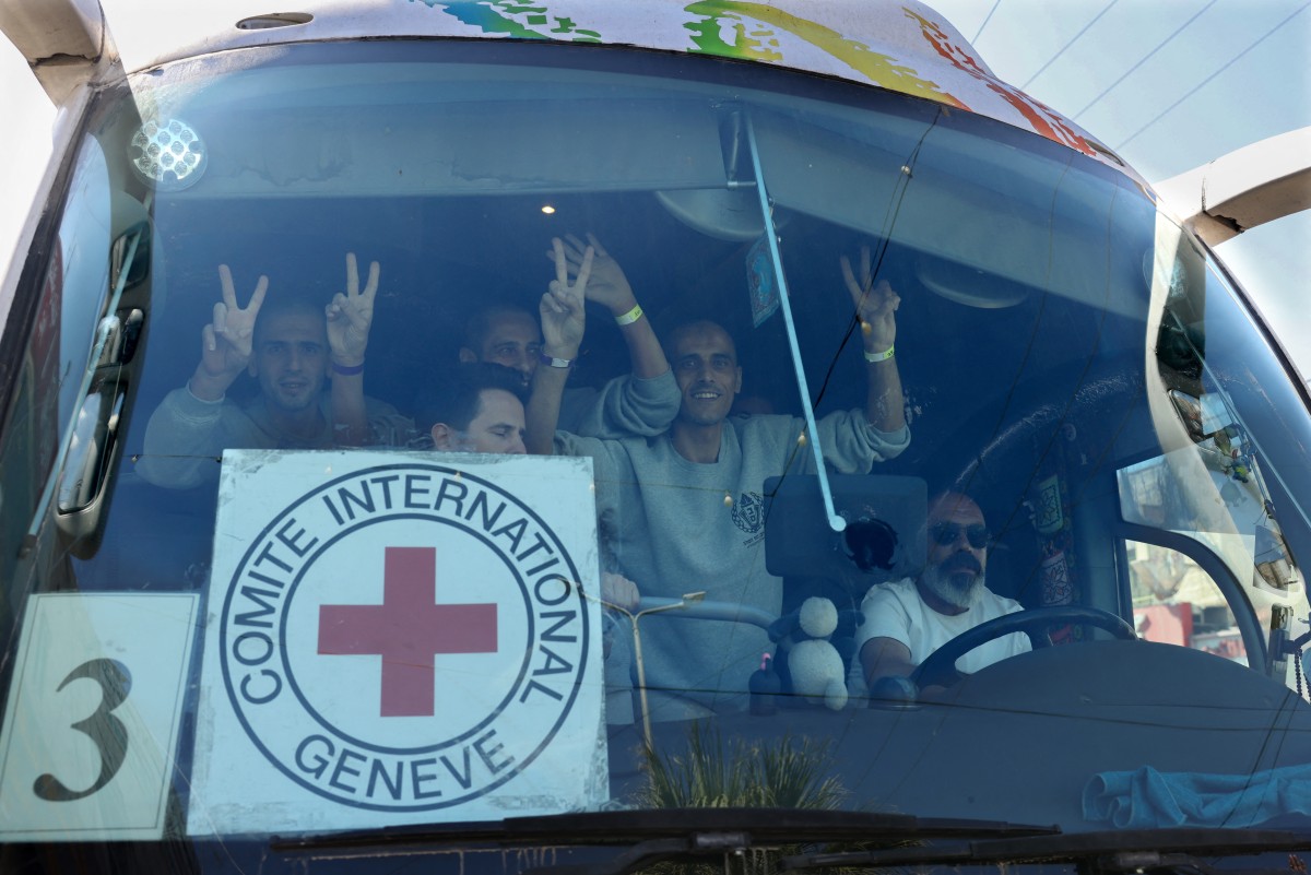 Palestinian men gesture from inside a bus after being released from the Ofer military prison located between Ramallah and Beitunia in the occupied West Bank, Oct. 13, 2025. (AFP)
