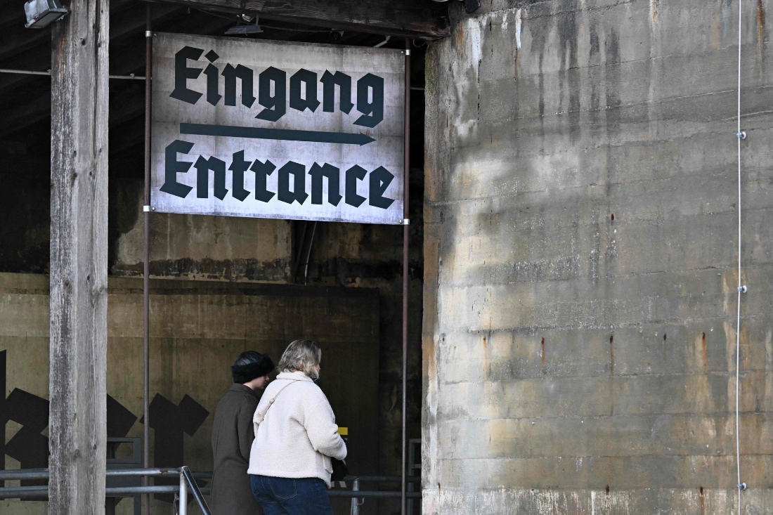 The entrance to the Berlin Story Bunker is seen as people walk under a sign reading 'Eingang' during a press presentation of the "Ukraine Museum" in the "Berlin Story Bunker" in Berlin, Germany. (AFP)