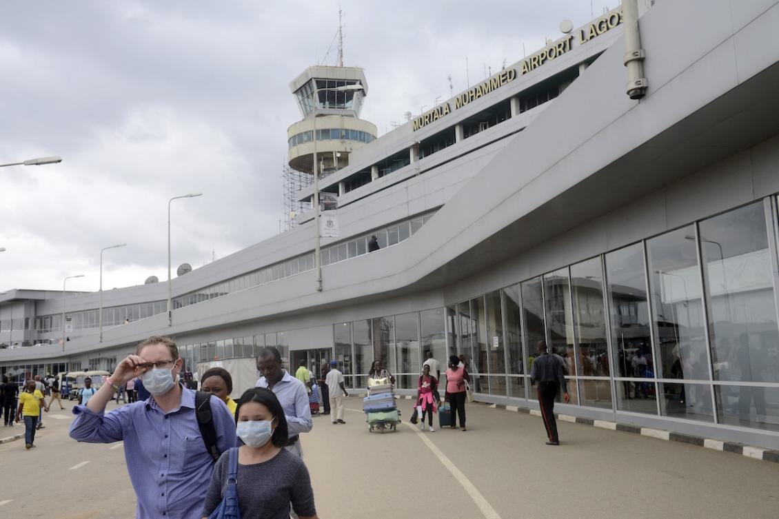 Two persons, wearing protective face masks walk upon arrival at the Murtala Mohammed Airport in Lagos on August 11, 2014. (FILE/AFP)
