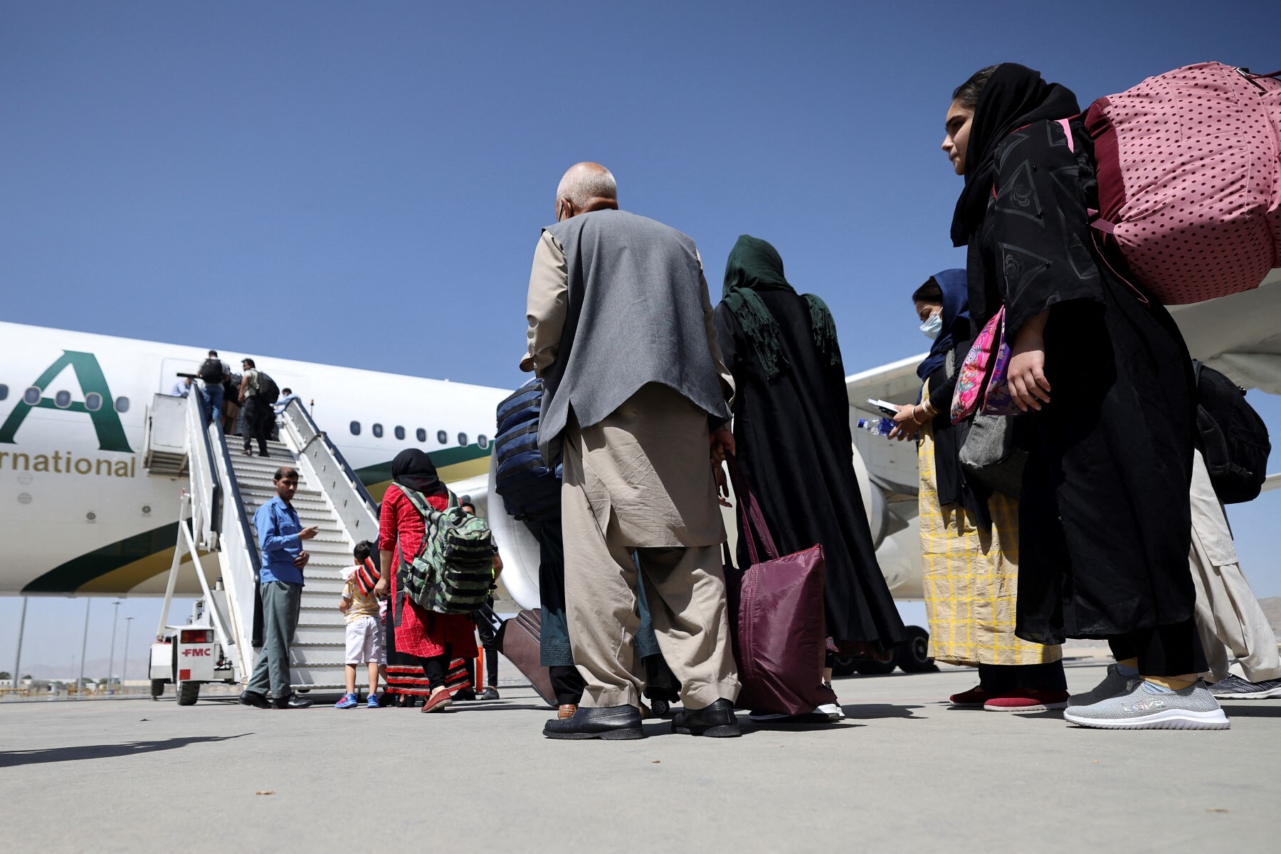Passengers stand in a queue to board a Pakistan International Airlines flight in Kabul on Sept. 13, 2021. (AFP/File)