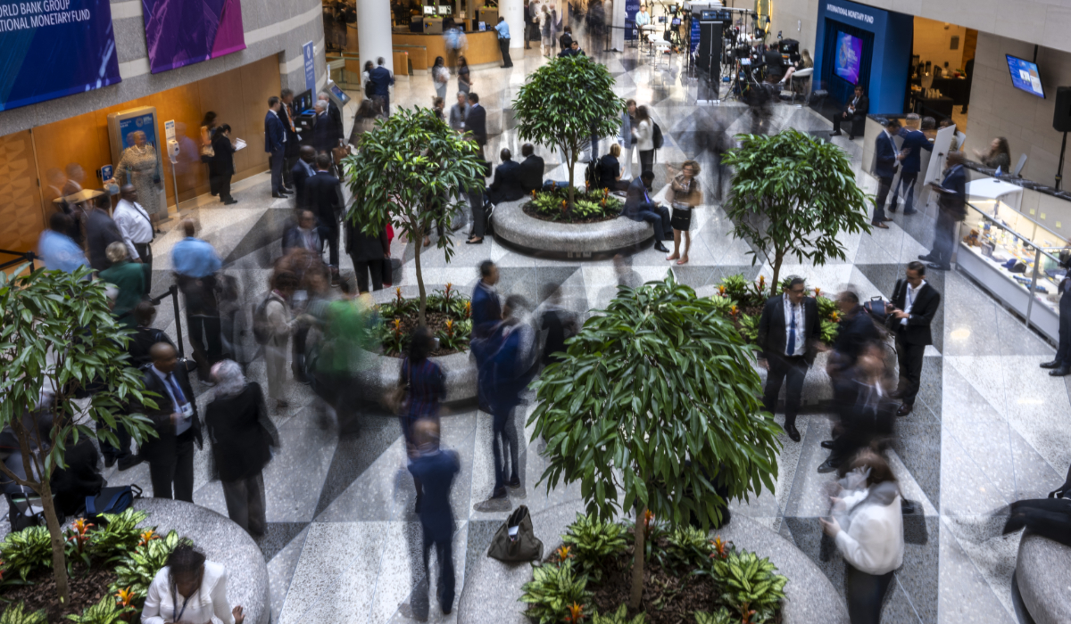 Guests and attendeess mingle and walk through the atrium during the IMF/World Bank Group Spring Meetings at the IMF headquarters in Washington, DC, on April 24, 2025. (AFP)