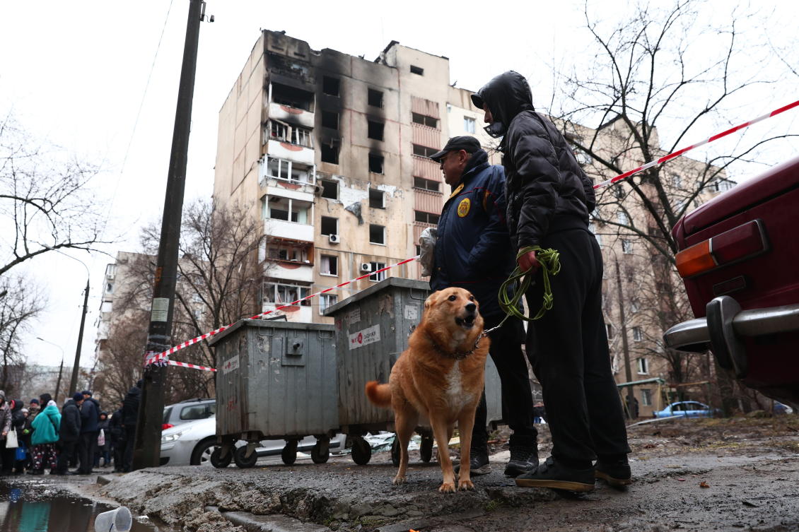 Local residents walk a dog near a damaged apartment building hit by Russian drone in Zaporizhzhia, Ukraine, Thursday, Feb. 26, 2026. (AP)