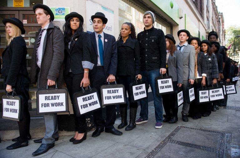 British musicians Miss Dynamite, fifth left, and Charlie Simpson, sixth left, join unemployed young people as they stand in line outside a job center in central London on Oct.10, 2011 during a photocall for the Battlefront Campaign. (AFP file photo)