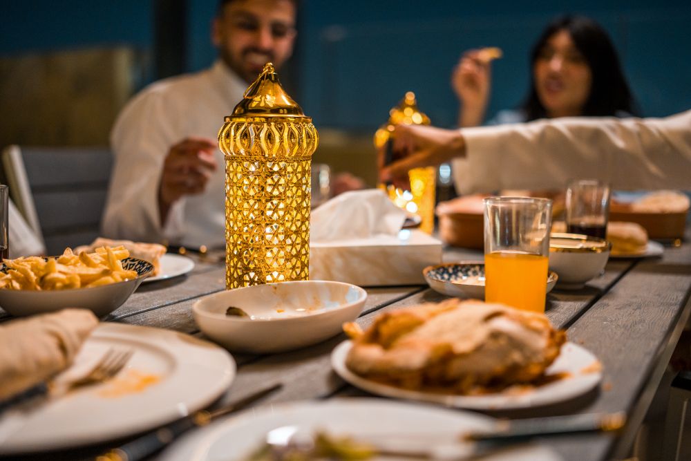 A group of young Arabic friends enjoy a cozy rooftop iftar. (E+)
