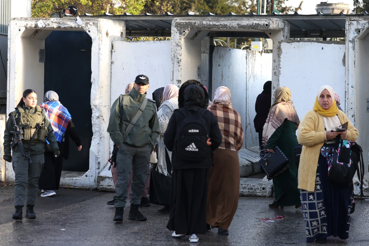 Israeli soldiers look on as Palestinian women approach a checkpoint, which they must pass to reach the Al-Aqsa Mosque in Jerusalem to attend the second Friday prayers of Ramadan on Feb. 27, 2026. (AFP)