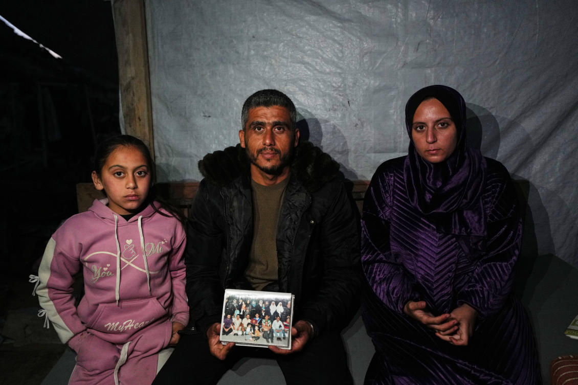 Saddam Al-Yazji, center, with his wife, Heba, and their daughter, Maryam, while holding a picture of their extended family — many of whom perished in an Israeli strike — in Gaza City on Feb. 24, 2026. (AP)
