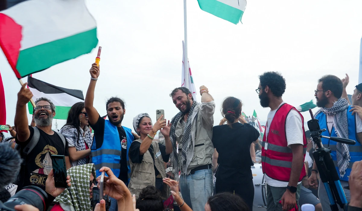 Brazilian activist Thiago Avila and activist Yasemin Acar, members of the Global Sumud Flotilla, surrounded by supporters of the Palestinian cause, gesture during a press conference on the beach of Sidi Bou Said, near Tunis, Tunisia, September 7, 2025. (REUTERS)