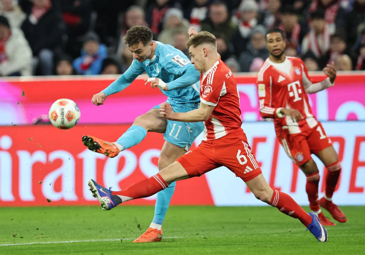 Hoffenheim's German forward #11 Fisnik Asllani (L) and Bayern Munich's German midfielder #06 Joshua Kimmich vie for the ball during the German first division Bundesliga football match between FC Bayern Munich and TSG 1899 Hoffenheim in Munich, southern Germany on February 8, 2026. (AFP)