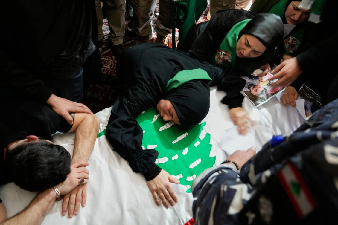 Relatives of policeman Hassan Jaber, who was killed on Monday by an Israeli drone attack, mourn over his coffin during his funeral procession in Yanouh village, south Lebanon, on Tuesday. (AP)