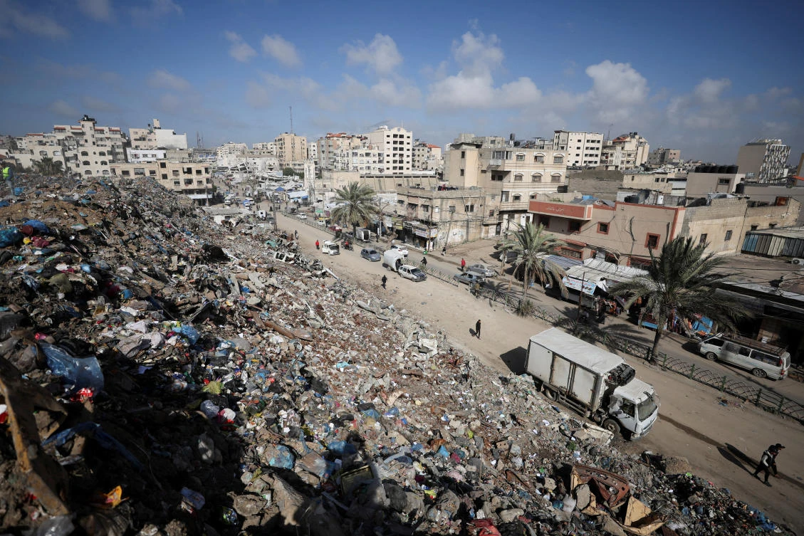 Palestinians walk near a landfill, in Gaza City, February 11, 2026. (REUTERS)