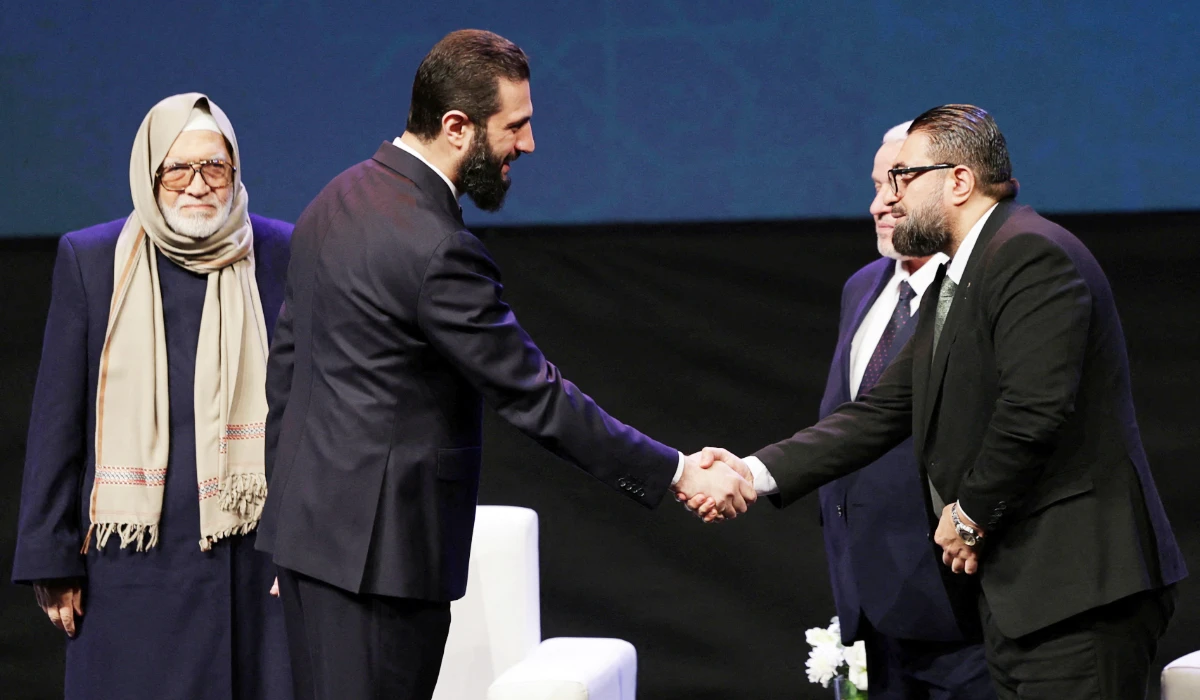 Syrian President Ahmed al-Sharaa shakes hands with Justice Minister Mazhar Al-Wais, during the Ministry of Awqaf conference titled "Unity of Islamic Discourse" at the Conference Palace in Damascus, Syria, February 16, 2026. (REUTERS)