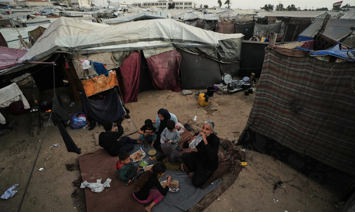 Displaced members of the Al-Zamil family break their fast on the first day of Ramadan inside their tent in Khan Younis, Gaza Strip, Wednesday, Feb. 18, 2026. (AP)
