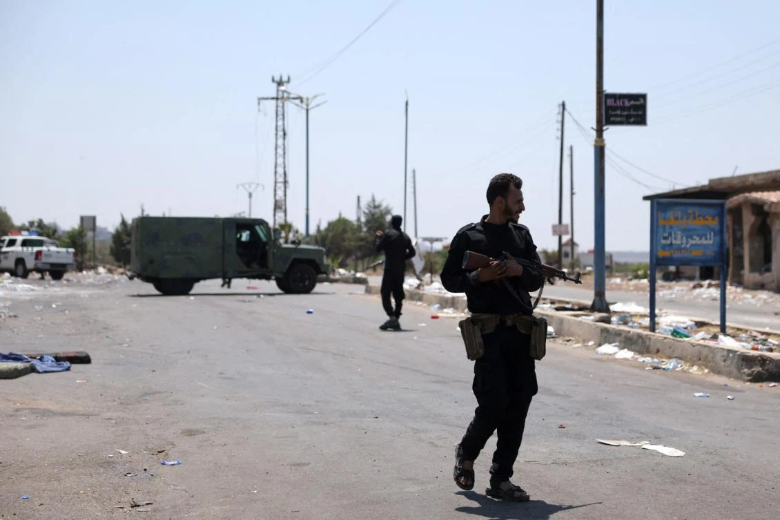 Above, Syrian government security forces stand guard at a checkpoint in the village of Walgha, near the city of Sweida, on July 21, 2025. (AFP file photo)
