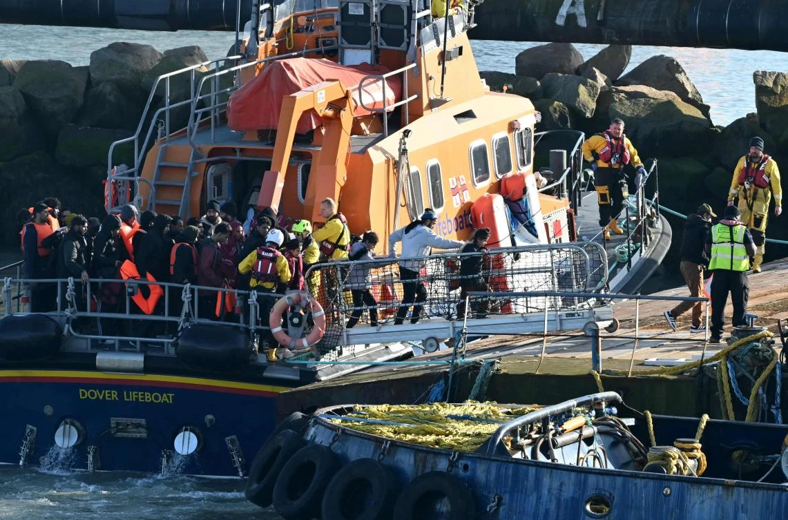 Migrants including children picked up at sea while attempting to cross the English Channel, are escorted off a National Lifeboat Institution (RNLI) Lifeboat upon arrival in Ramsgate, southeast England, on Feb. 25, 2026. (AFP)
