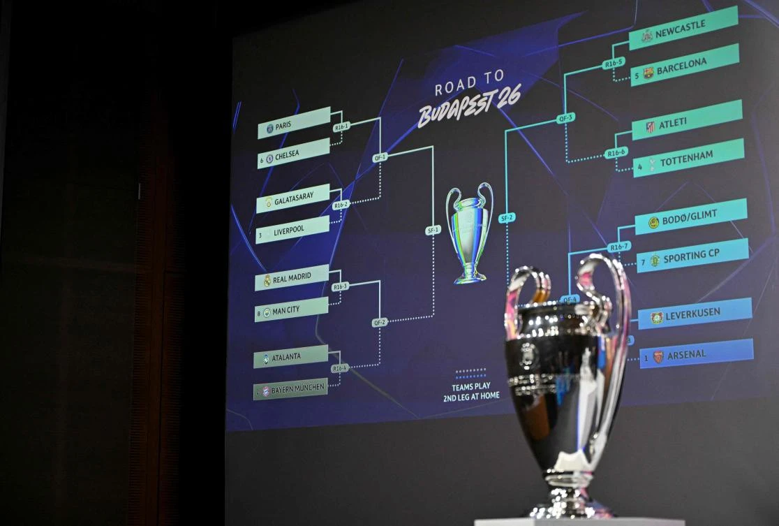 This photograph shows the UEFA Champions League Cup displayed next to a screen bearing the results of the 2025-2026 UEFA Champions League round of 16, quarter-final and semifinal draw at the House of European Football in Nyon, Switzerland on Feb. 27, 2026. (AFP)