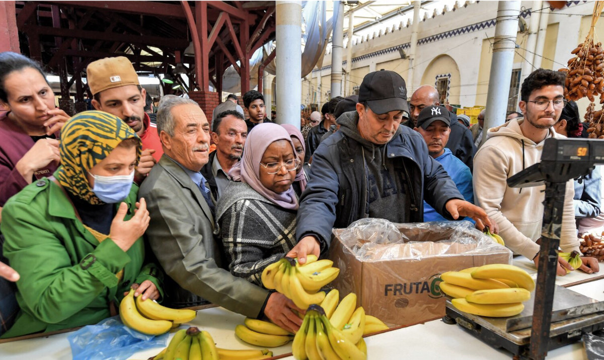 A produce merchant weighs bananas for customers at the Central Market in Tunis. (AFP/File)