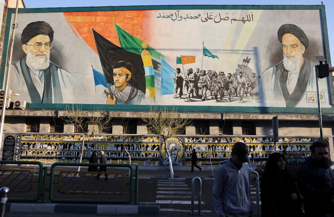 People walk near a mural featuring images of Iran's Supreme Leader Ayatollah Ali Khamenei and the leader of Iran's 1979 Islamic Revolution Ayatollah Ruhollah Khomeini in Tehran, Iran. (Reuters)