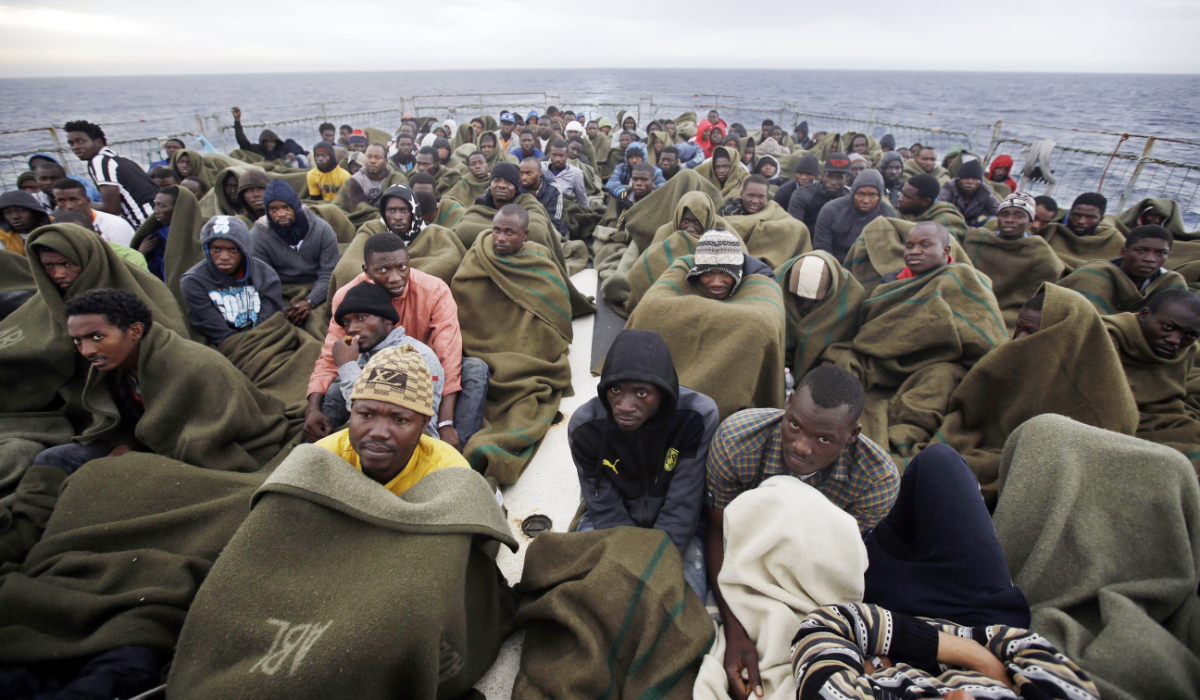 Migrants sit on the deck of the Belgian Navy vessel Godetia after they were saved at sea during a search and rescue mission in the Mediterranean Sea off the Libyan coasts, Wednesday, June 24, 2015. (AP)