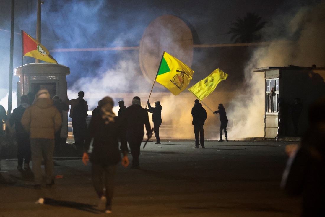 A protester holds a Kataib Hezbollah flag as supporters of Iraqi Shi'ite armed groups attempt to move toward the U.S. embassy in Baghdad's Green Zone, Iraq. (Reuters)
