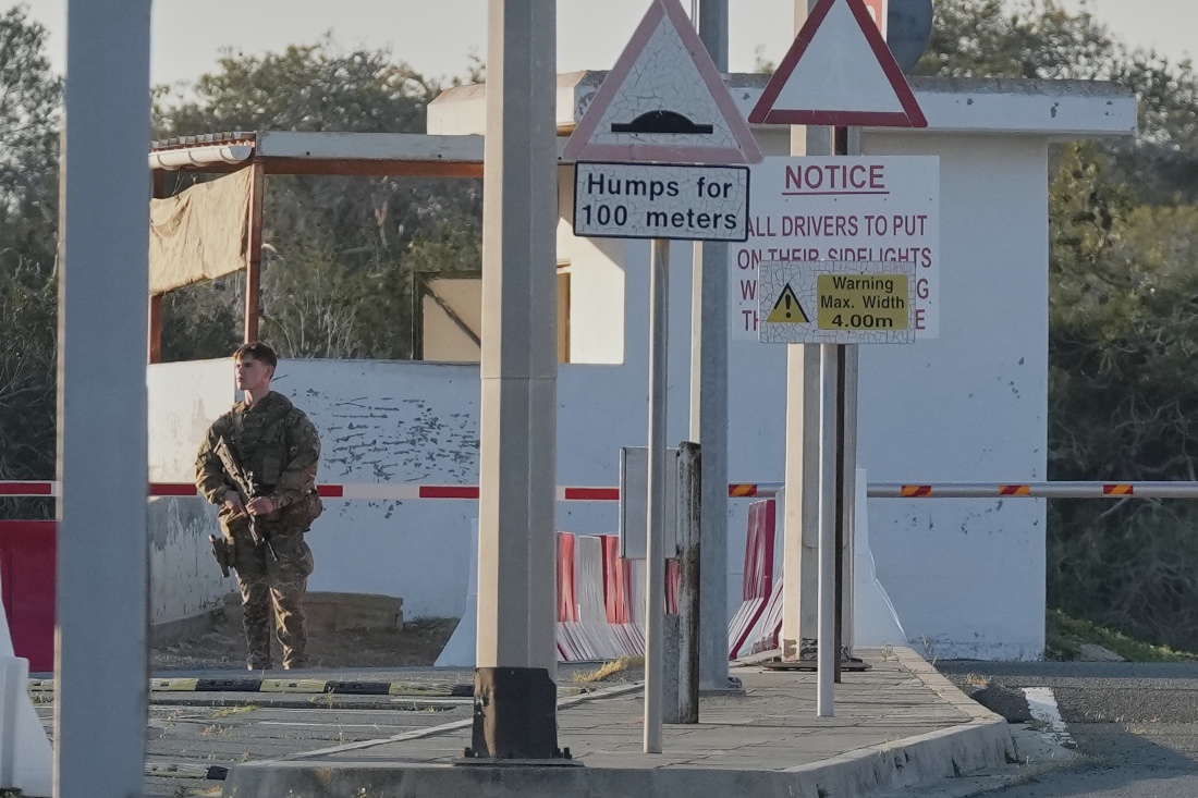 A British soldier stands guards at the main gate of the UK's RAF Akrotiri base after it was hit by a suspected drone strike early morning near Limassol, Cyprus. (AP)