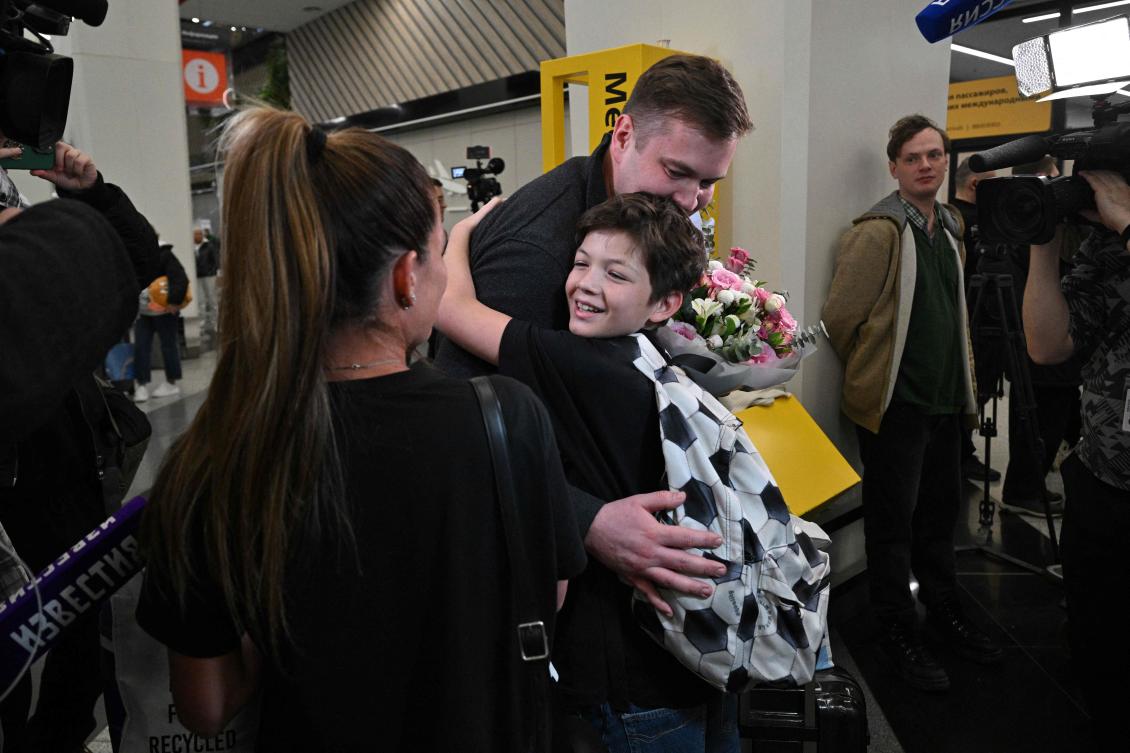 A man welcomes passengers, arriving from Abu Dhabi, at Sheremetyevo International Airport in Moscow on March 2, 2026. (AFP)