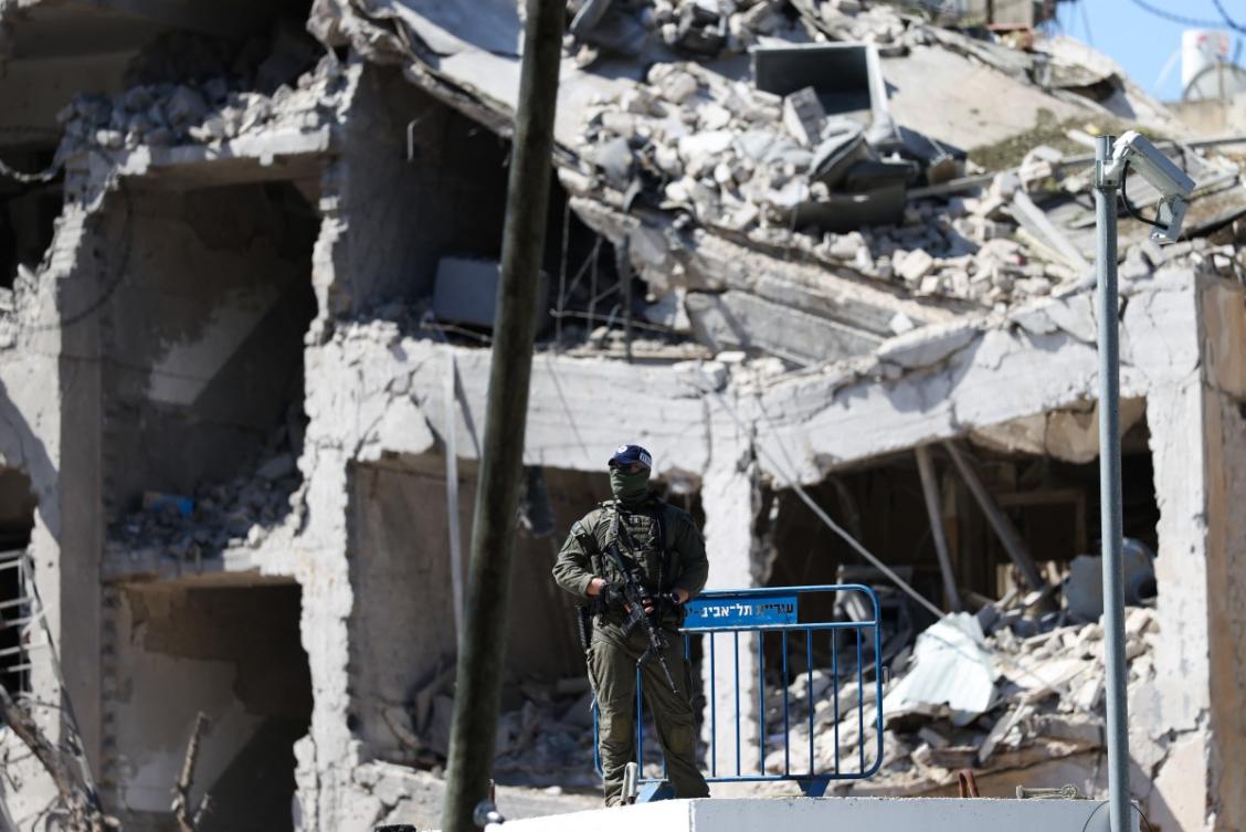 An Israeli soldier guards an area in front of a destroyed building that was hit by a reported overnight Iranian strike in Tel Aviv on March 1, 2026. (File/AFP)
