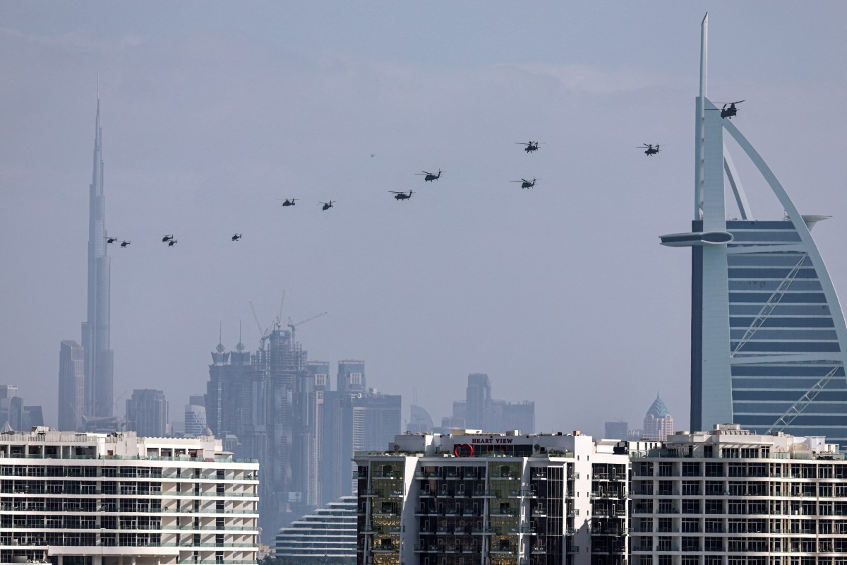 United Arab Emirates army helicopters fly from Burj al Arab hotel (R) towards Burj Khalifa, in Dubai on January 16, 2026. (File/AFP)