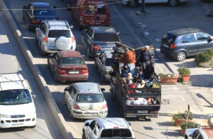 A family rides in the back of a truck as motorists block the roads as they flee villages in southern Lebanon along the coastal road through the city of Sidon on Mar. 2, 2026. (AFP)