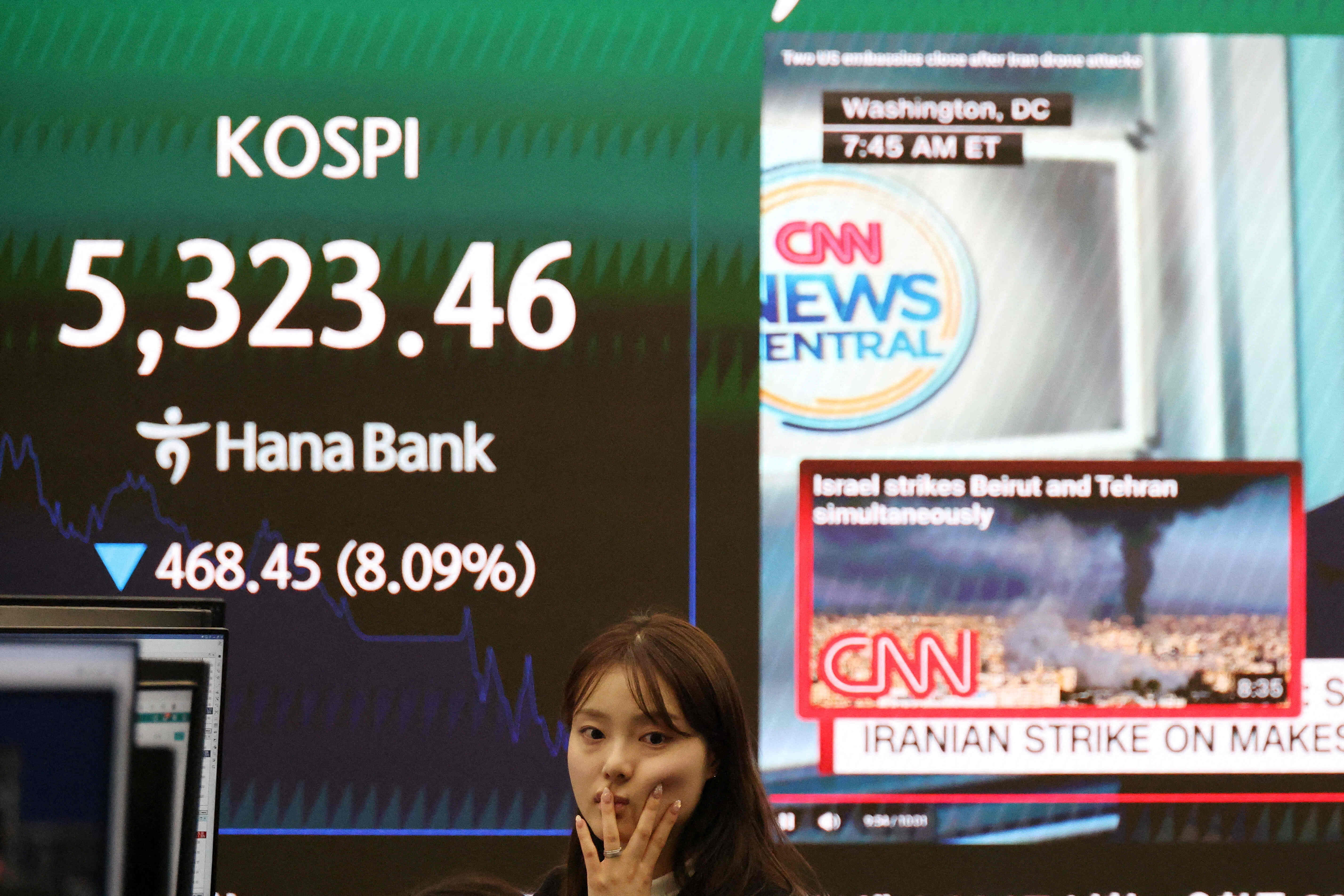 A currency dealer works in front of an electronic board displaying the Korea Composite Stock Price Index (KOSPI) and a news report on the US-Israeli conflict with Iran, at the dealing room of a bank, in Seoul, South Korea, March 4, 2026. REUTERS/Kim Hong-Ji