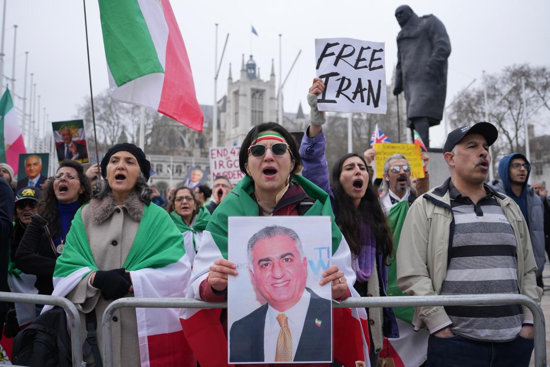 Protesters hold up placards showing Iran's exiled crown prince Reza Pahlavi during a rally outside the parliament in London, Wednesday, March 4, 2026. (AP)