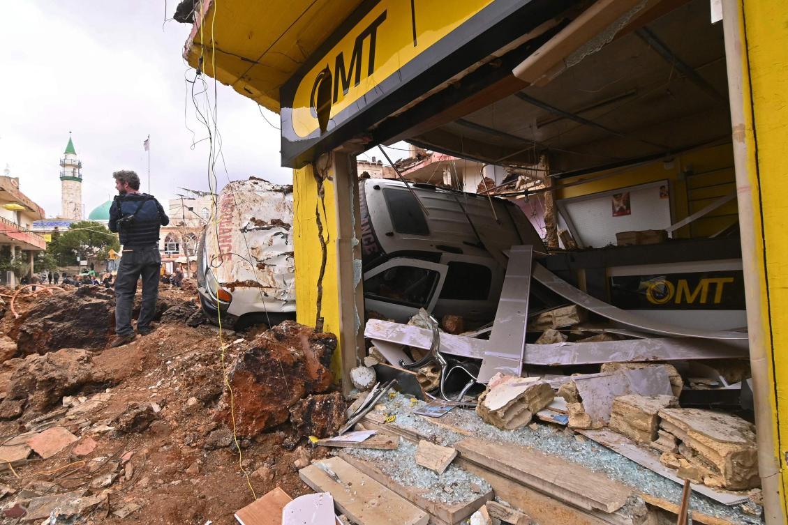 This photograph taken during a media tour organized by the Hezbollah shows a photographer standing next to an overturned ambulance at Nabi Sheet town after an Israeli military operation in the Bekaa Valley of Lebanon, on Mar. 7, 2026. (AFP)