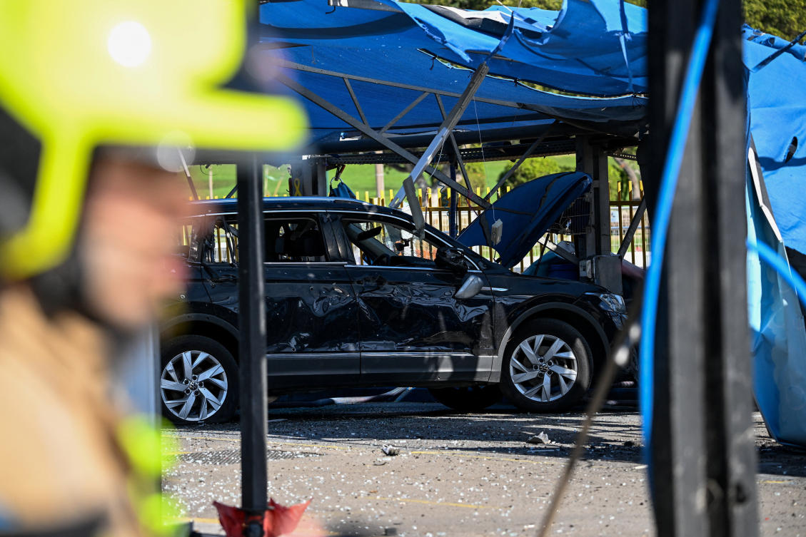An Israeli emergency responder stands near a damaged vehicle in central Israel on March 8, 2026. (Reuters)