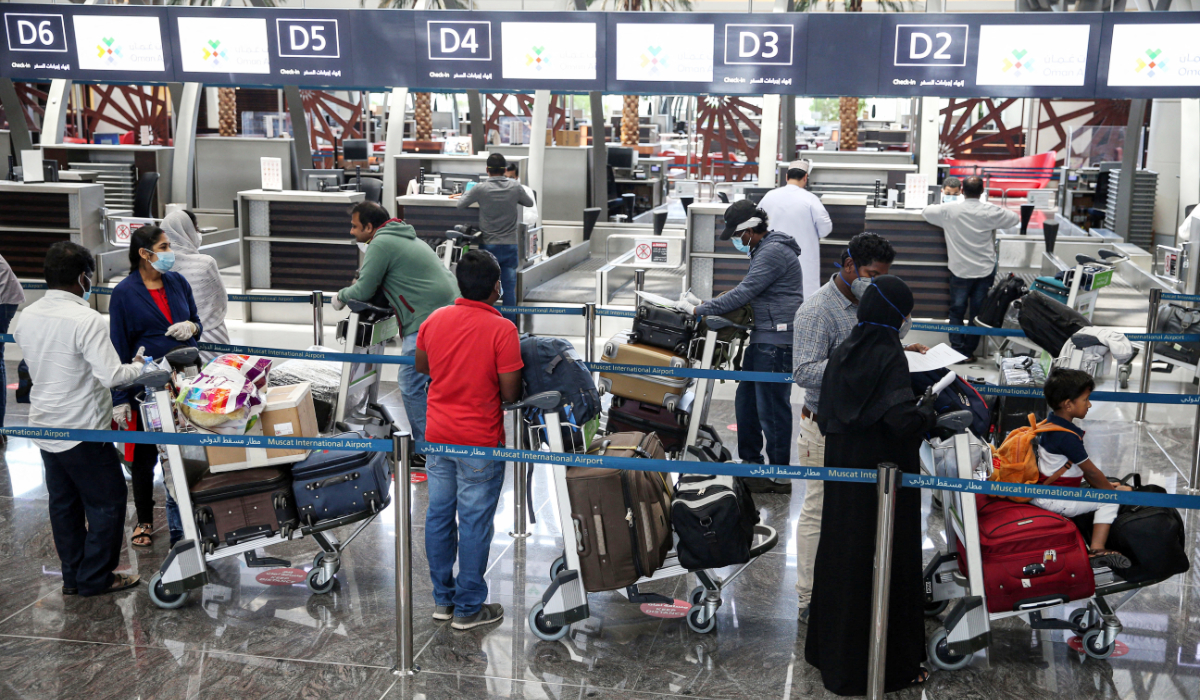 Passengers queue with their luggage at the check-in counter at a terminal in Muscat International Airport. (AFP file photo)