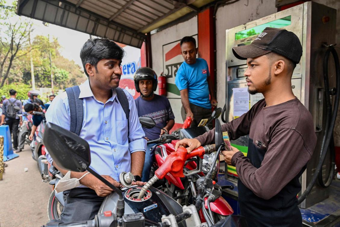 A man gets his motorcycle refueled at a fuel station in Dhaka on March 8, 2026. Bangladesh launched fuel rationing on March 8 as an energy crunch deepened due to the war in the Middle East, creating long queues at filling stations and spilling over into anger. (Photo by Munir UZ ZAMAN / AFP)