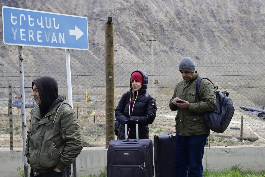 Iranian refugees stand with their belongings after crossing the border from Iran to Armenia at a border check point in the southern Armenian town of Meghri, on March 9, 2026, amid the Middle East war. (FILE/AFP)