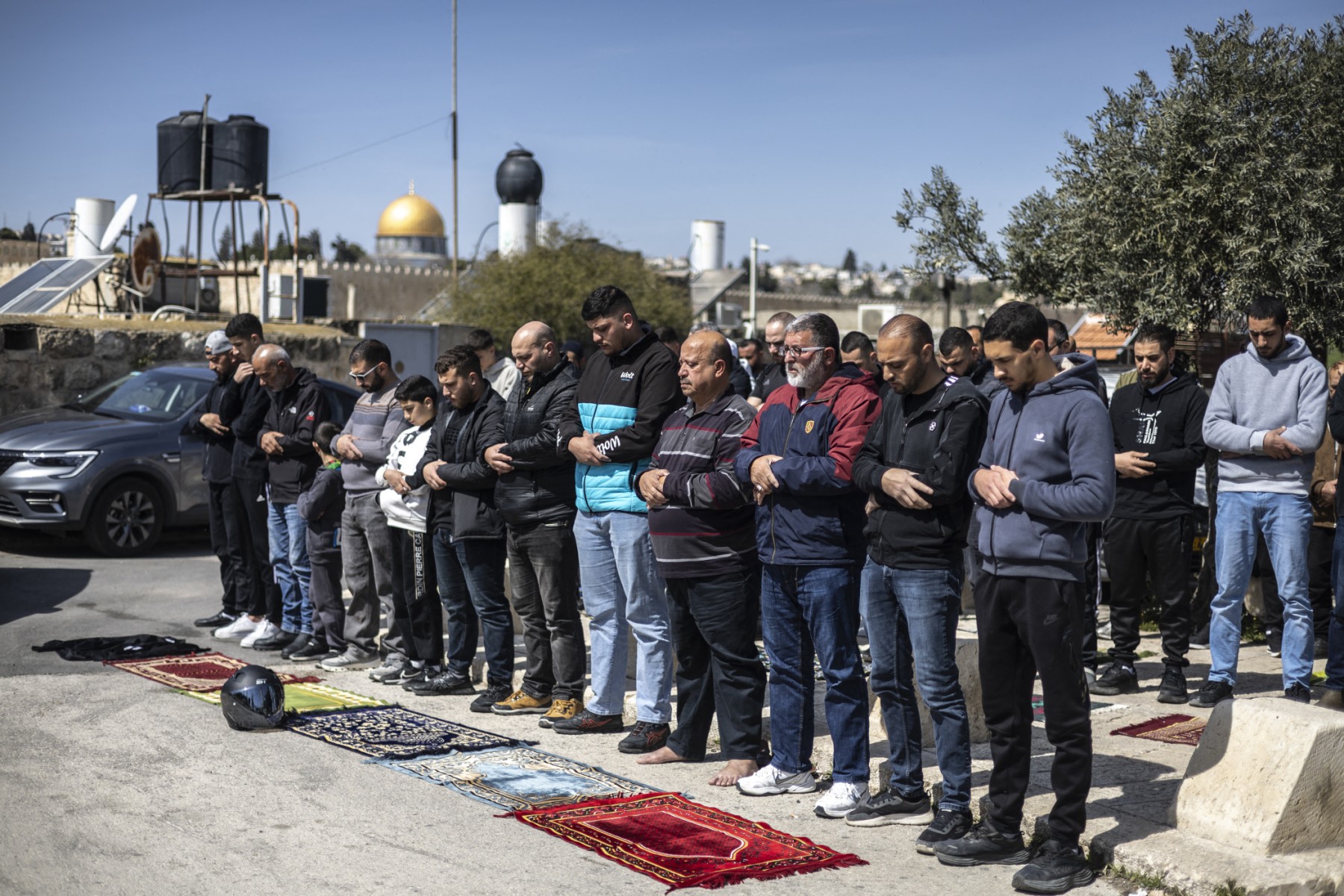 Muslim worshippers perform Friday prayers on the street near Ras al-Amud Mosque in Israeli-annexed east Jerusalem, overlooking the Al-Aqsa compound and the Dome of the Rock, March 6, 2026. (AFP)