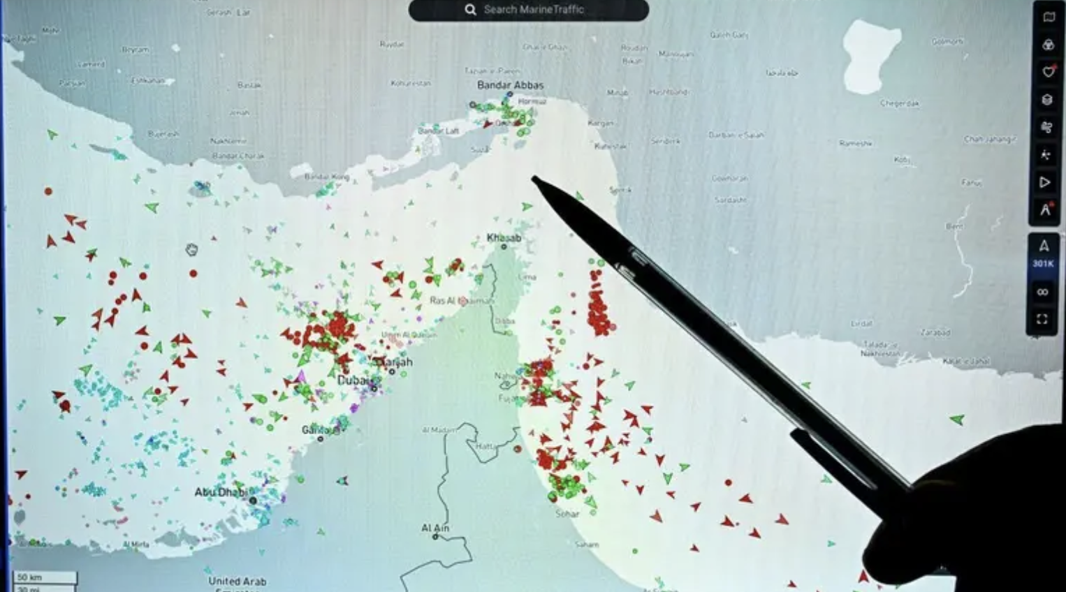 A person points to a page on the MarineTraffic website showing commercial vessel traffic near Iran’s coast at the edge of the Strait of Hormuz on March 4, 2026. (AFP)