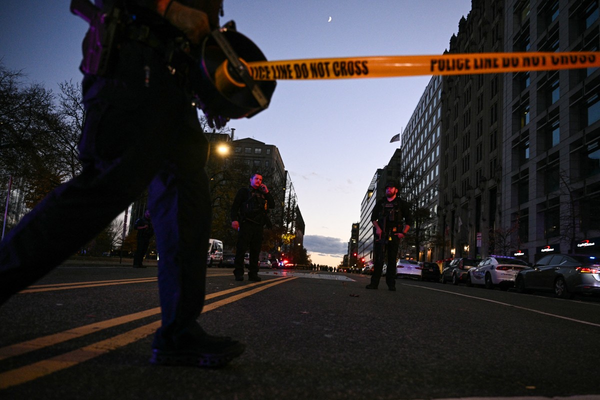 Police officers secure the area as law-enforcement officials visit the crime scene of a shooting in downtown Washington, DC, on November 26, 2025. (AFP)
