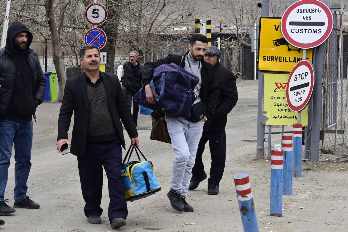 Iranian refugees walk with their belongings after crossing the border from Iran to Armenia at a border check point in the southern Armenian town of Meghri, on March 8, 2026, amid the Middle East war. (FILE/AFP)