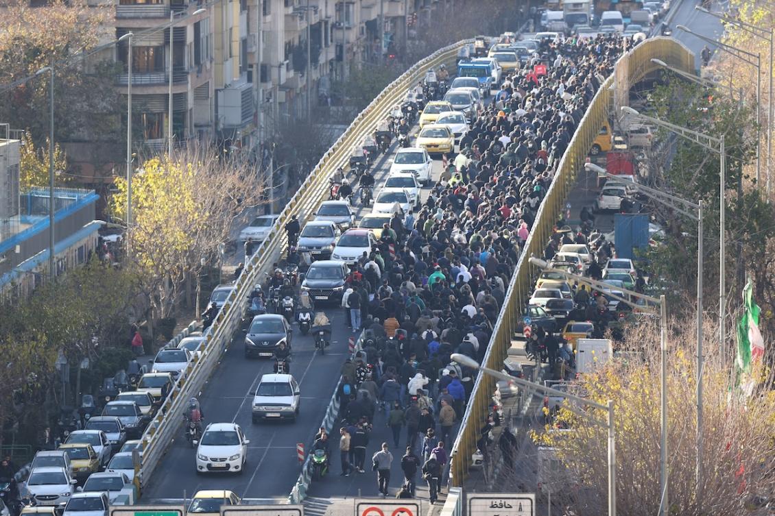 Shopkeepers and traders walk over a bridge during a protest against the economic conditions and Iran's embattled currency in Tehran on December 29, 2025. (FILE/AFP)