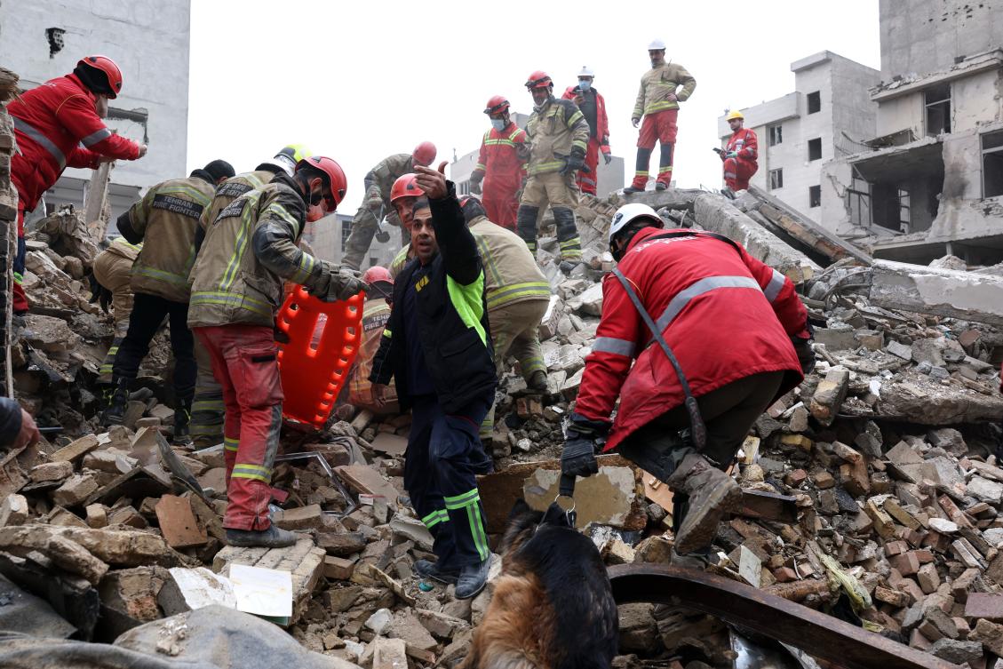 Rescue workers search for survivors in the rubble after a strike in southern Tehran on Friday. (AP)