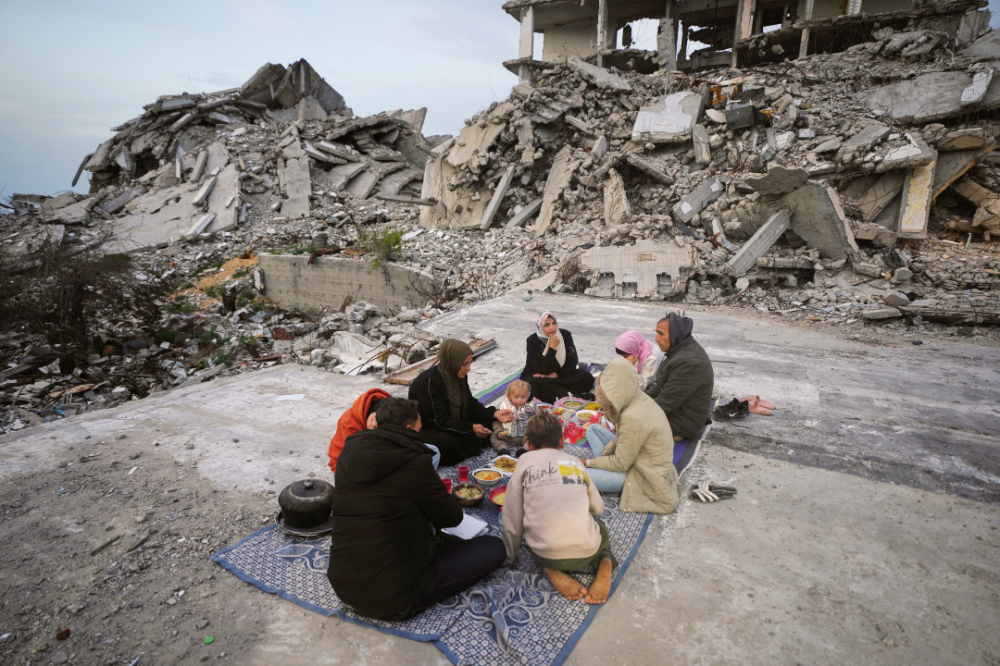 Members of the Al-Najar family break their fast during the Muslim holy month of Ramadan amid the rubble of destroyed buildings in Gaza City. (AP)